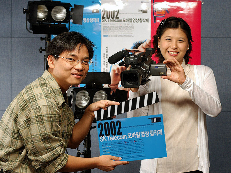 SK Telecom holds `2002 SK Telecom Mobile Film Creation and Production Festival` and supports production of 20 movies. The company is also accepting public entries by mail and on-line for the Amateur division. The photo shows the making of a mobile movie to enter in the contest.